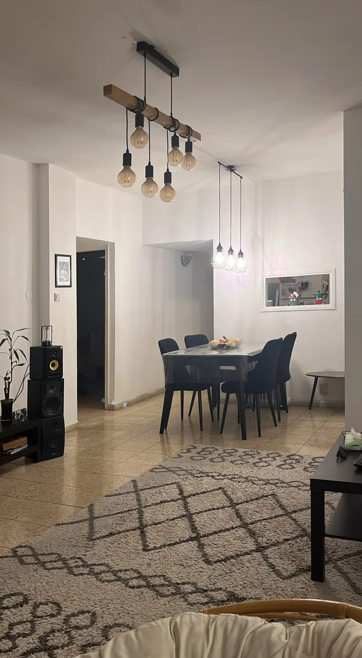 לפני: צילום טלפון של הסלון ופינת האוכל, עם המנורות הקיימות